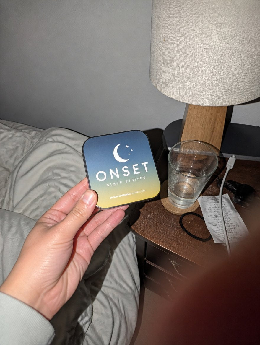 Onset Sleep Strips tin held beside a bedside table with a lamp and glass of water